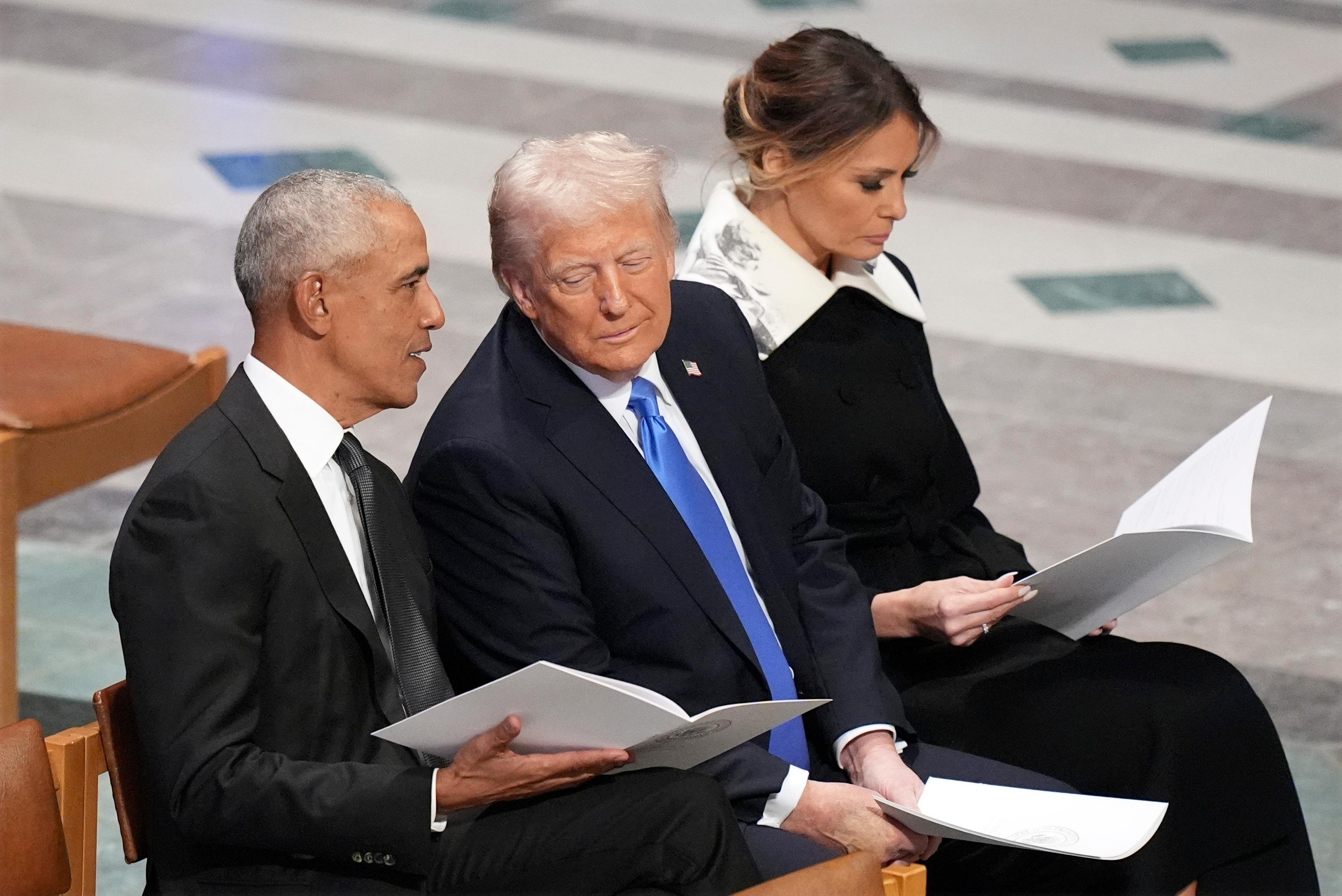 FILE – Former President Barack Obama talks with then President-elect Donald Trump as Melania Trump reads the funeral program before the state funeral for former President Jimmy Carter at Washington National Cathedral in Washington, Jan. 9, 2025. (AP Photo/Jacquelyn Martin, File)
